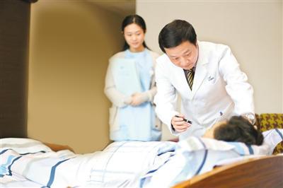 詹主任在住院部诊视手术后病人。